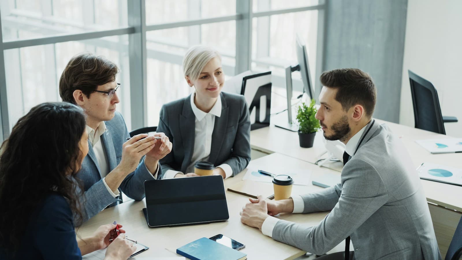 Colleagues discussing a handover around a meeting table