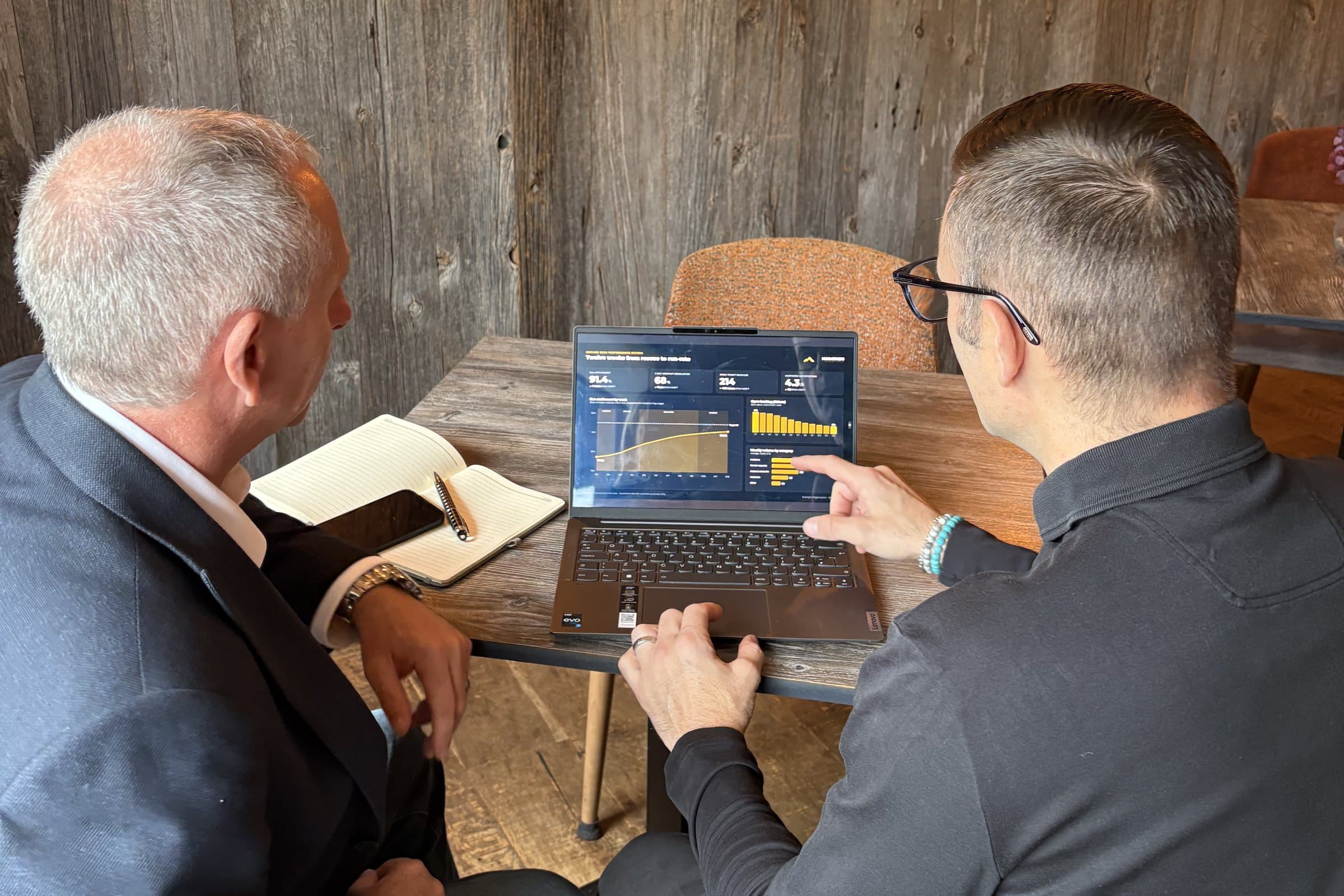 Greg Spanner pointing out a trend on a performance dashboard during a working session (illustrative data)